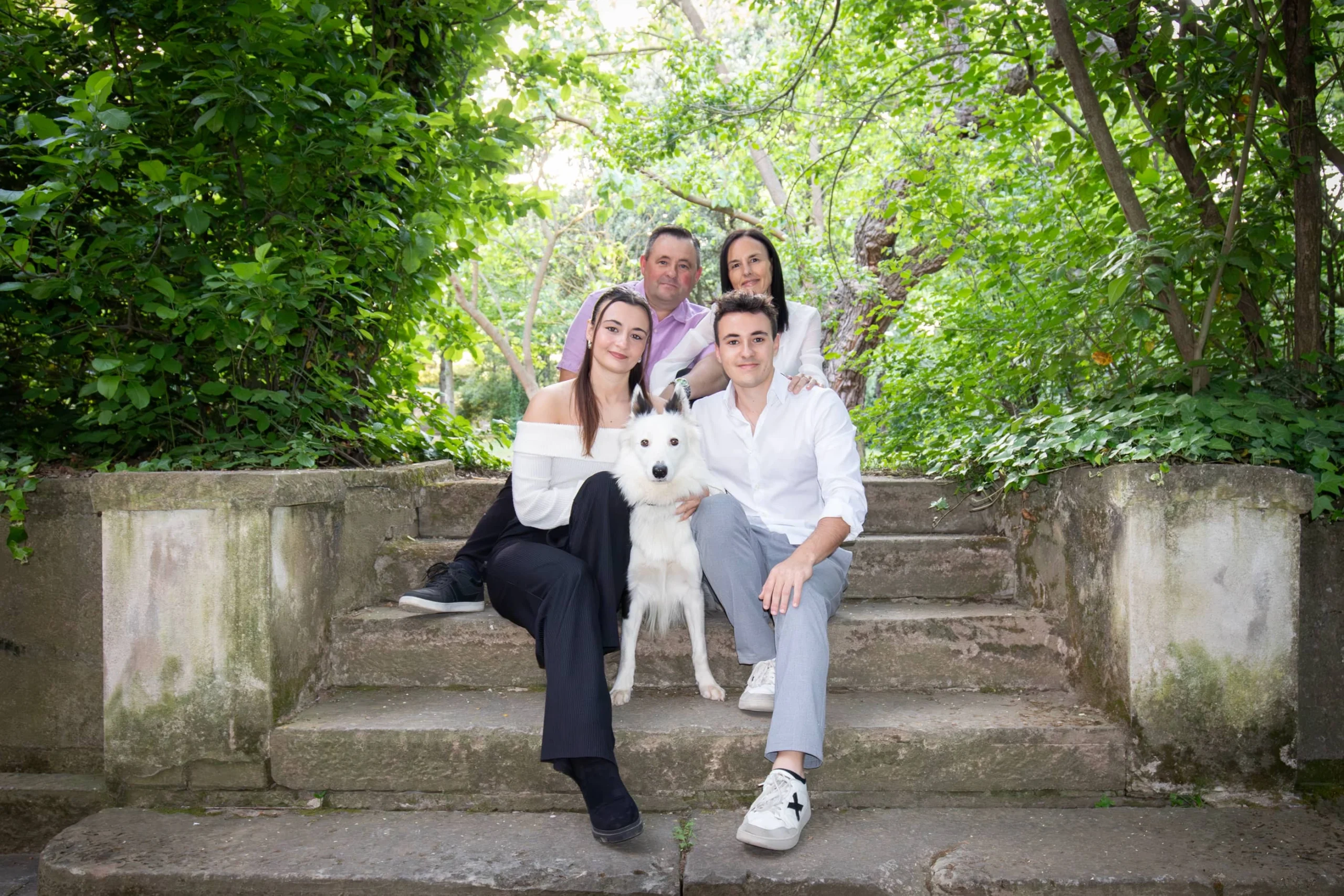 Família gaudint d'una sessió de fotos amb el seu Border Collie en un entorn natural del Bages.