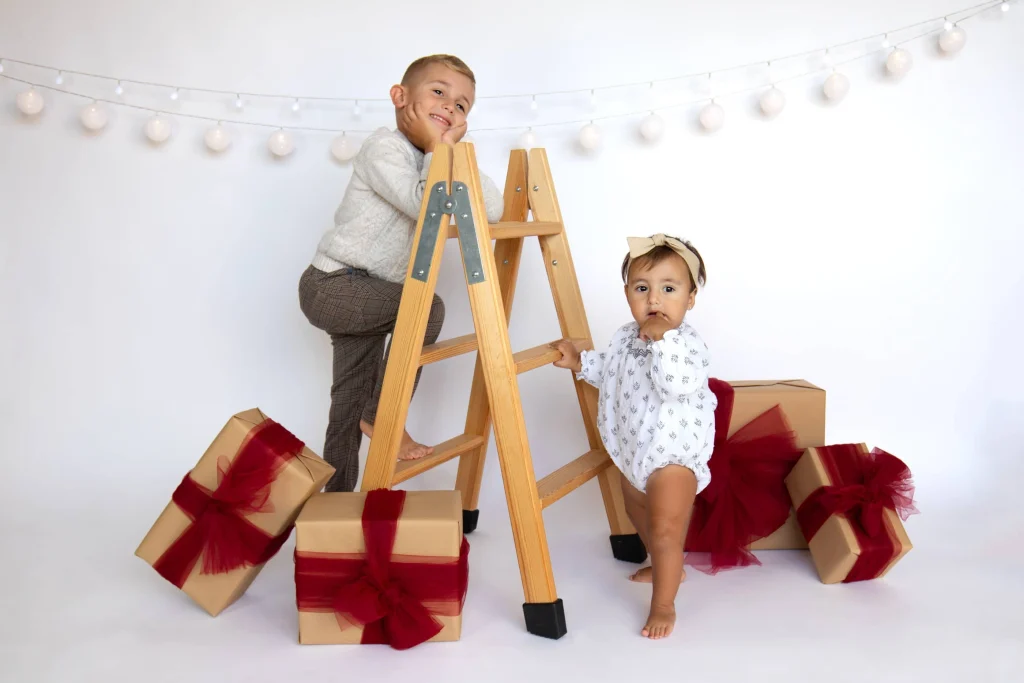 Fotos de hermanos en una sesión de Navidad en estudio fotográfico
