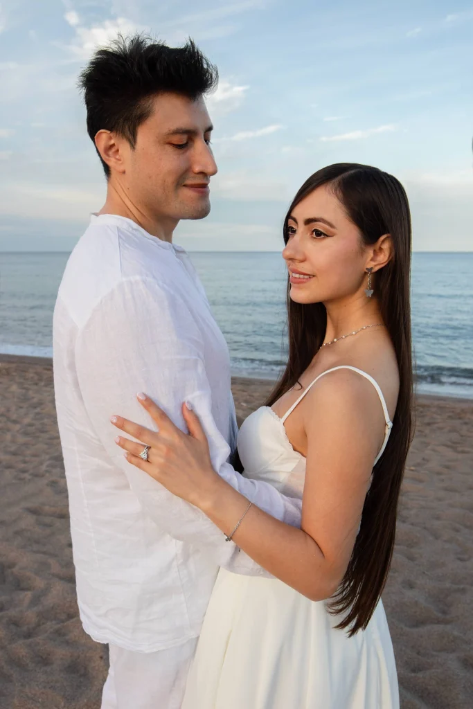 Sesión fotográfica de preboda en la playa, pareja junto al mar con luz natural.